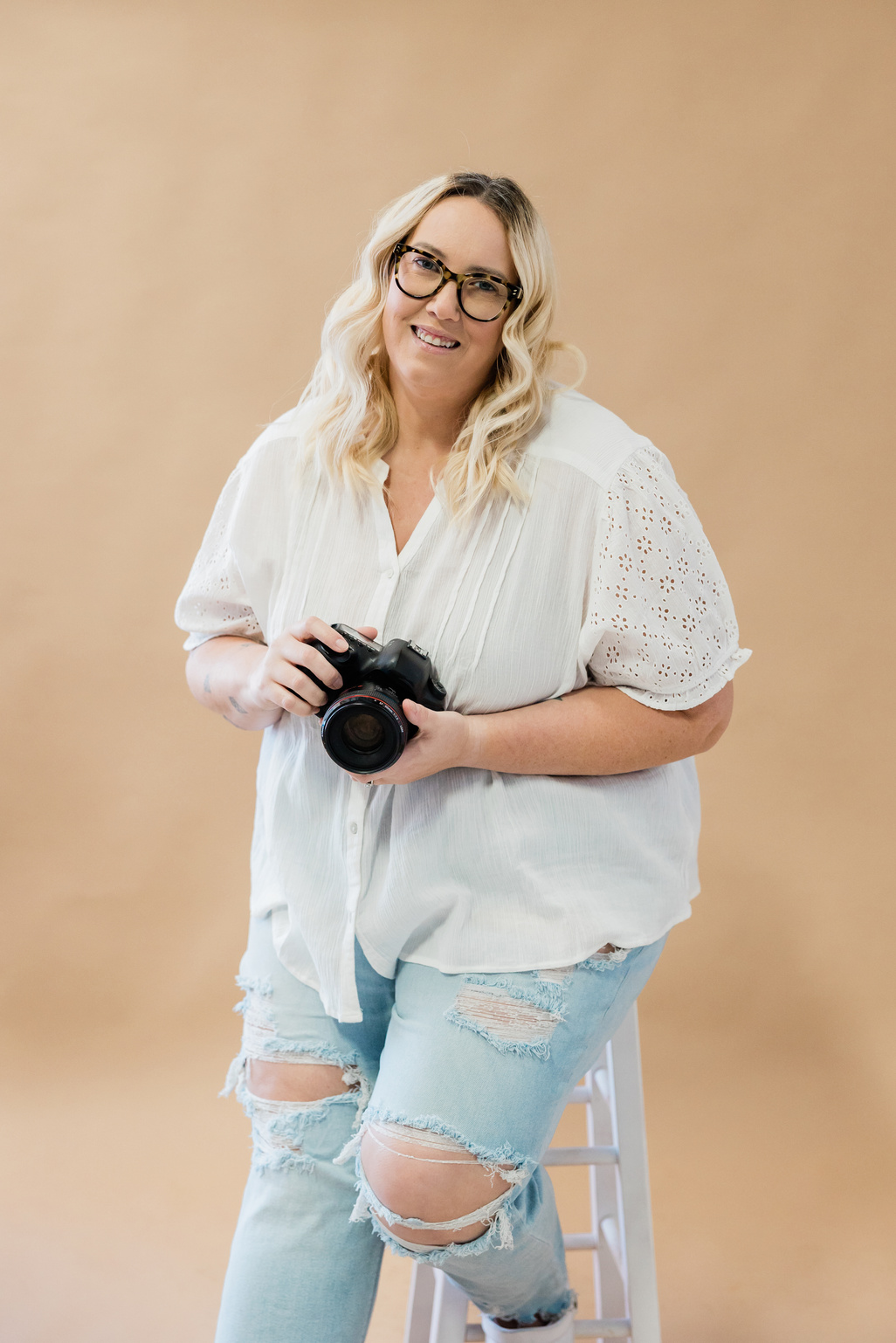 Female Photographer Holding a Professional Camera in Studio